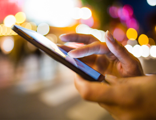 Manos de una persona manipulando un teléfono móvil.